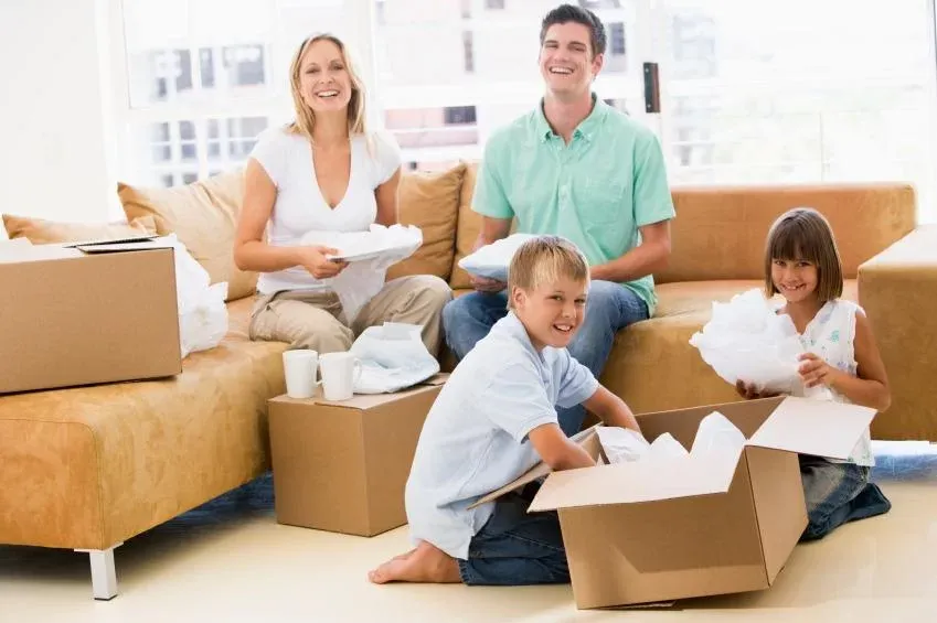 Happy family unpacking boxes in their new home